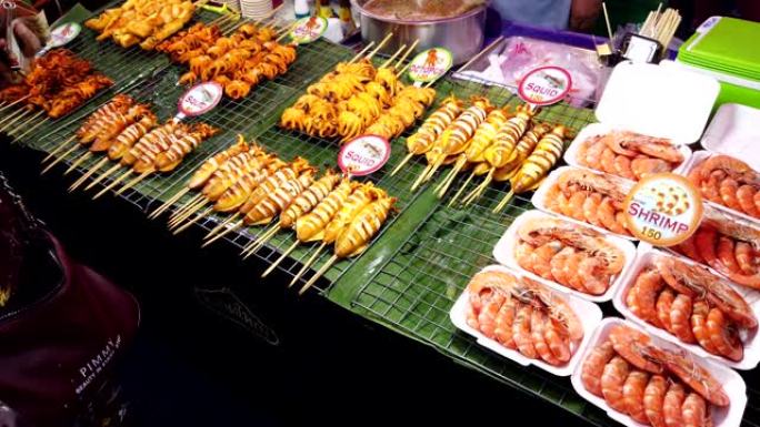 夜食市场上各种海鲜，烤虾或虾和鱿鱼的餐桌前视图