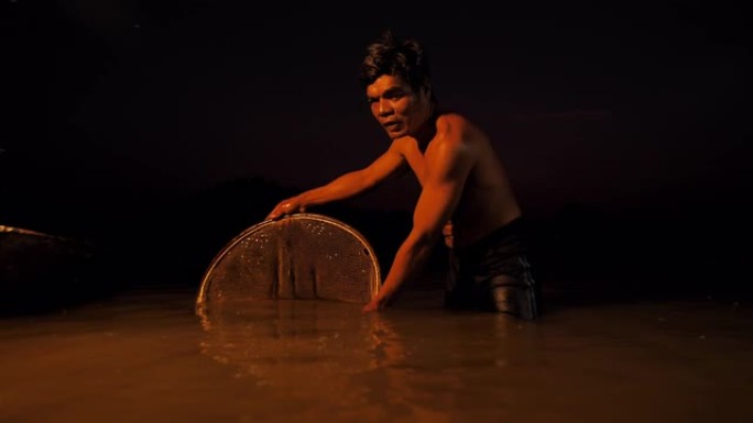 渔民们在湖边黄昏时用勺子网捕虾。概念渔夫的生活方式。华富里，亚洲，泰国。
