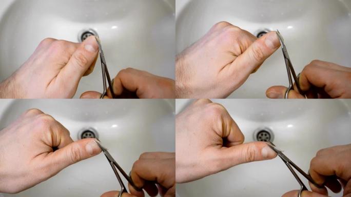 早上用手指剪刀在水槽或洗手盆上的男性指甲美容