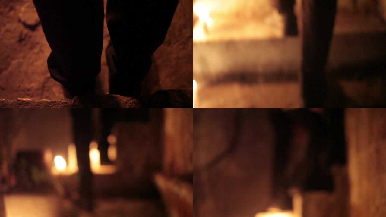 在一个令人毛骨悚然的地方爬上楼梯的男性的人形/身体的轮廓点亮了蜡烛和灯笼。