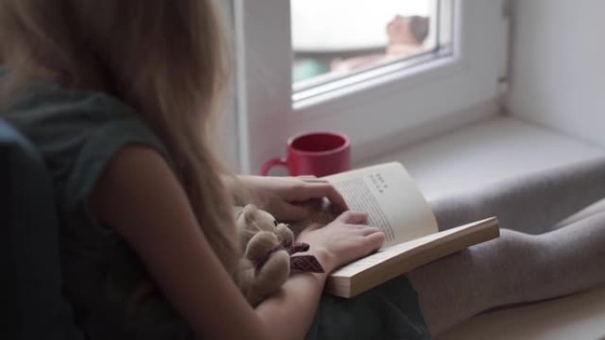 窗台上绿松石连衣裙阅读用泰迪熊的小女孩