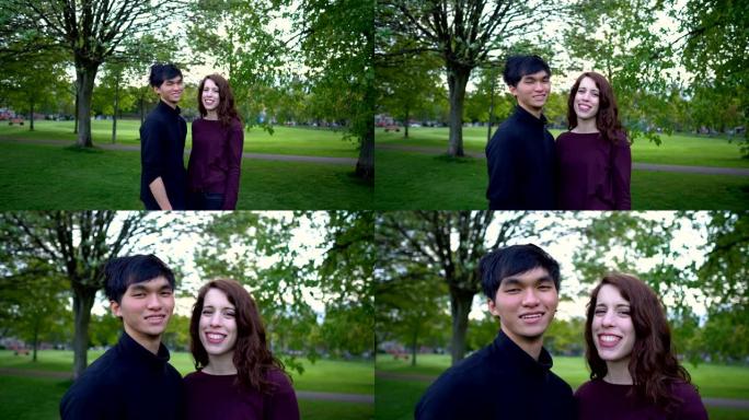 自信的年轻混合种族夫妇肖像站在公园-白人妇女和亚洲男子