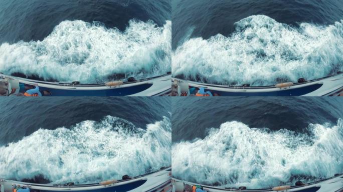 高速渡轮在船的侧面留下大浪。从上层看。游客们走下甲板，看着海浪。