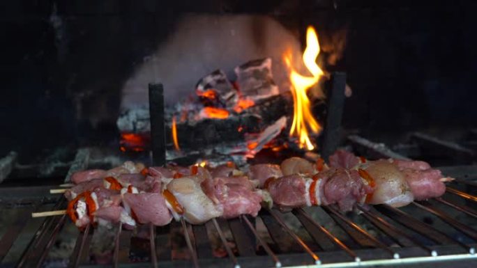 烤肉架上的肉类分类，在4k中燃烧木炭。用洋葱和红辣椒在砖壁炉的烤架上烧烤猪肉和牛肉。野餐炒肉，烧烤概