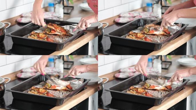 库克切煮熟的鱼，厨师用菜刀切煮熟的鳟鱼的特写镜头。