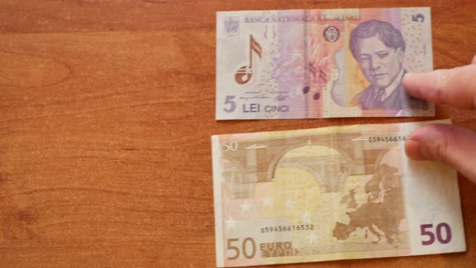 男子移动两张纸币罗马尼亚列伊和欧元