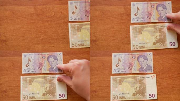 男子移动两张纸币罗马尼亚列伊和欧元