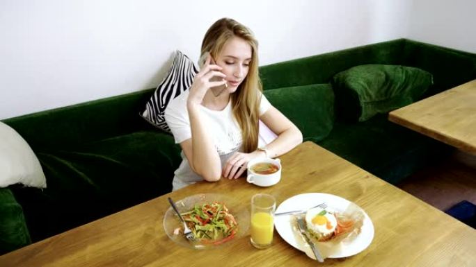 美丽的女人在现代咖啡馆使用手机，在手机上聊天。4K