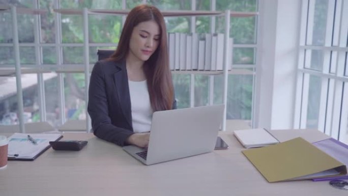 肖像亚洲美丽的女孩或女人用电脑在工作场所做生意。网上购物，转账，网上银行，幸福意味着一切作为灵感概念