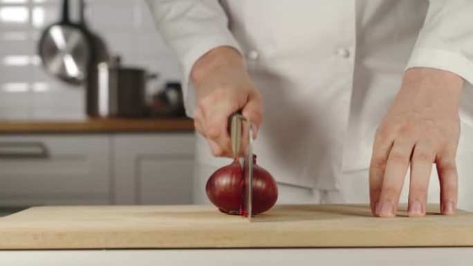 慢动作: 厨师在烹饪时在木板上切碎红洋葱头