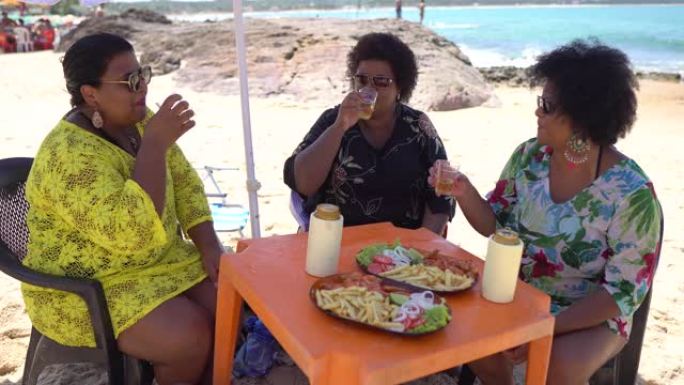妇女在巴西伯南布哥州佩德拉德萨雷乌海滩的海滨餐厅吃饭和喝酒