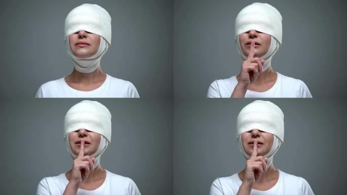 戴头巾的女人表现出沉默的手势，抬起脸和矫正视力