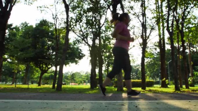 亚洲女性跑步、公园慢跑和傍晚晒太阳的慢动作侧视图。良好的健康和锻炼