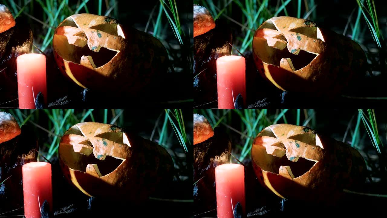 为万圣节制作的南瓜灯。一个南瓜和一根红色燃烧的蜡蜡烛。4K