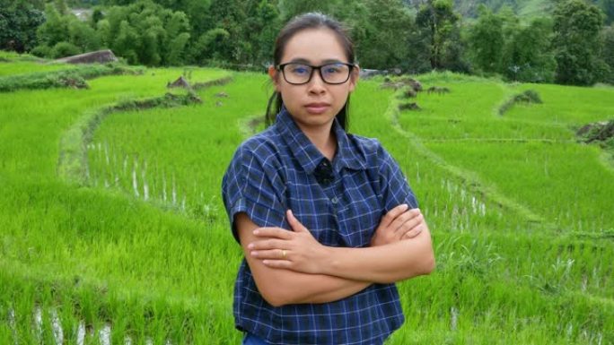 亚洲农民妇女站在温室沙拉水培农场上，双臂交叉在农田里自豪。