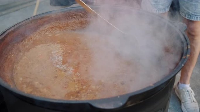 厨师正在大锅中搅拌汤炖牛肉