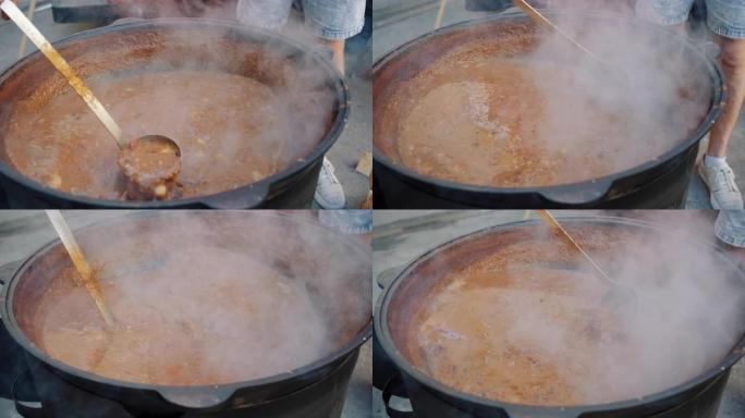 厨师正在大锅中搅拌汤炖牛肉