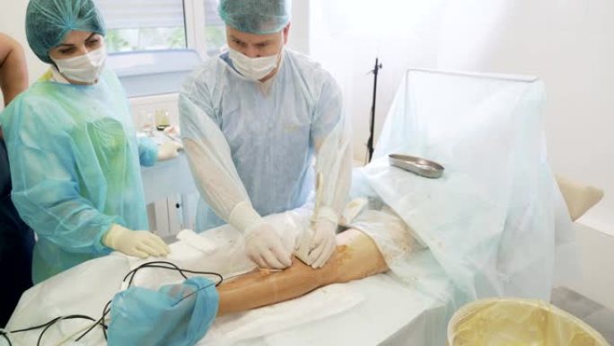 外科医生在患者腿部插入特殊仪器，并在切除静脉曲张时进行超声检查