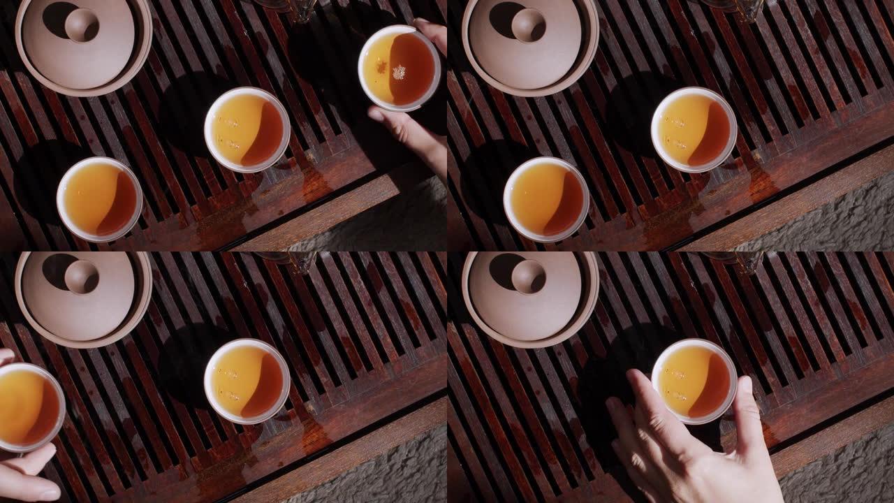 人们用茶杯装满热茶的手的俯视图
