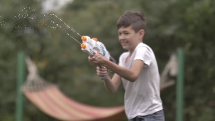 快乐男孩在村里户外射击水枪