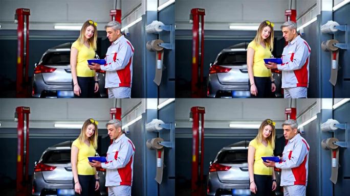 汽车修理工和客户文件在汽车修理厂检查-4k分辨率