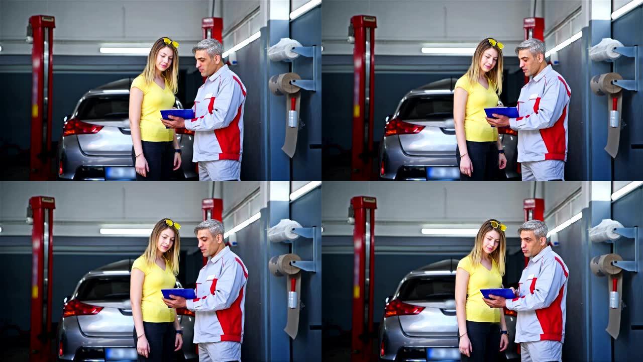 汽车修理工和客户文件在汽车修理厂检查-4k分辨率