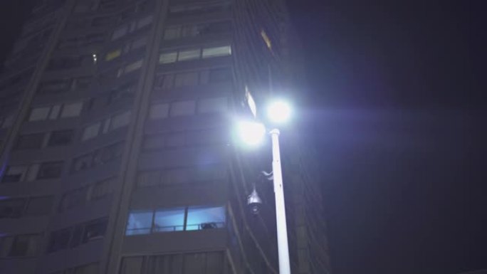 法国巴黎-2019年7月16日: 晚上在巴黎商业区用玻璃窗在摩天大楼下点灯，慢速平移然后转身，倒影。