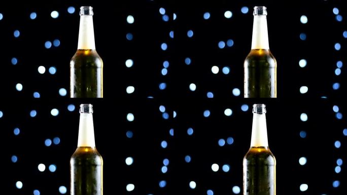 啤酒在一个打开的瓶子在黑色背景上旋转，明亮的灯光