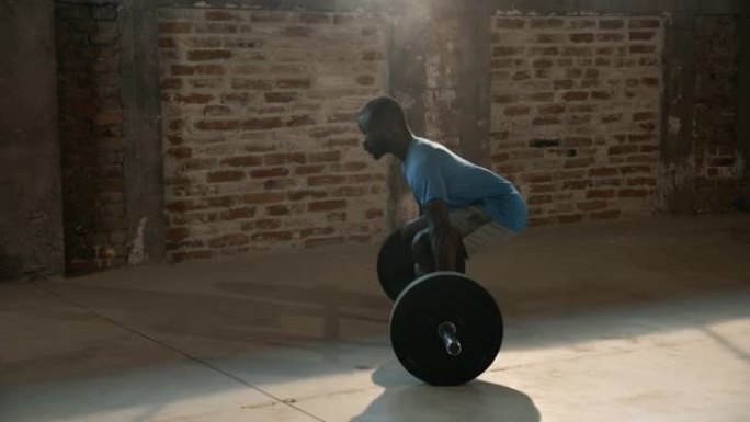 运动男子在手上使用粉笔粉并在健身房举重