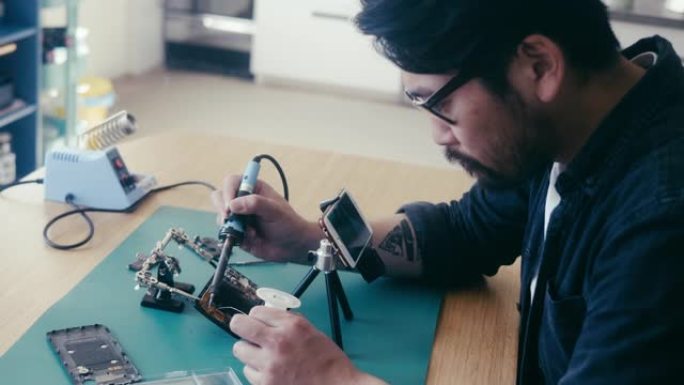一名日本男子在视频中讲述如何修理智能手机