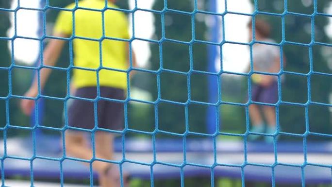 蹦床公园里的网，学童在背景中跳跃