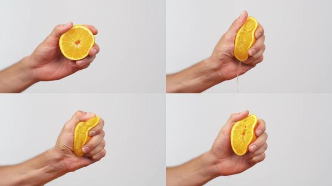 用手挤出新鲜的橙子。柑橘汁从果肉和水滴中排出。孤立，在白色背景上