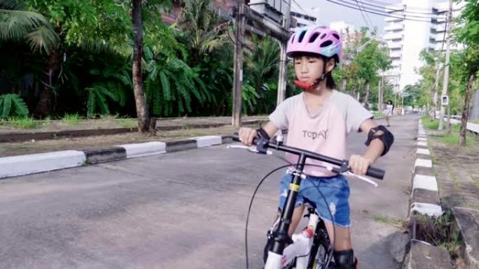 女孩在街上骑自行车。