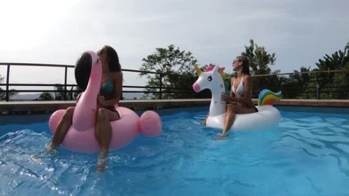 两个朋友在带游泳池的私人别墅里聚会 -- 快乐的年轻人用异形床垫寒意