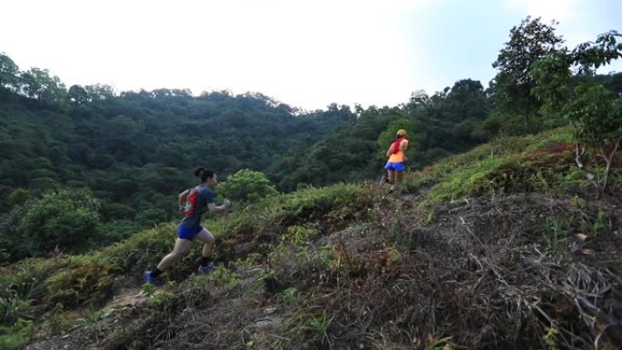 女子越野跑运动员在热带森林的山坡上奔跑