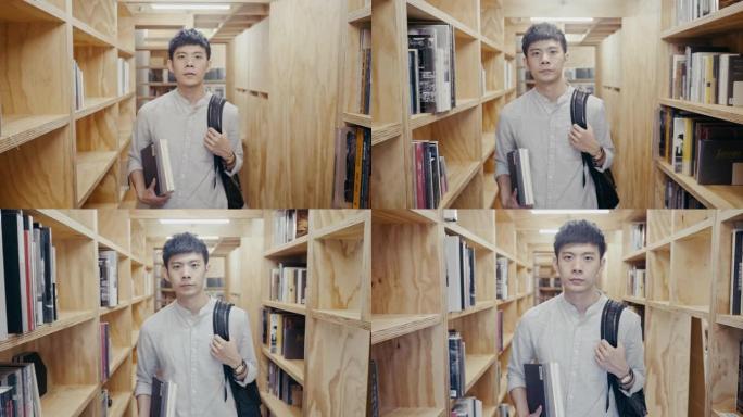 一名年轻的亚洲男学生在书架之间行走的肖像 (慢动作)