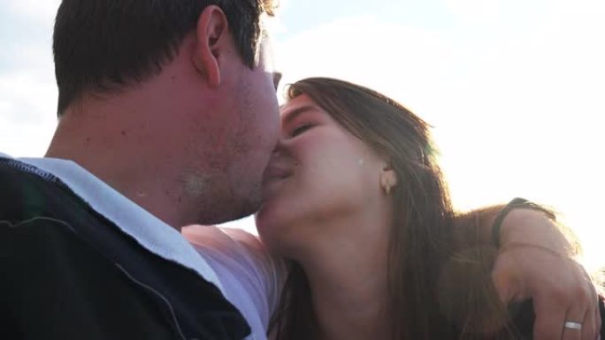 肖像男朋友和女朋友当他们亲吻特写背景蓝天4K。