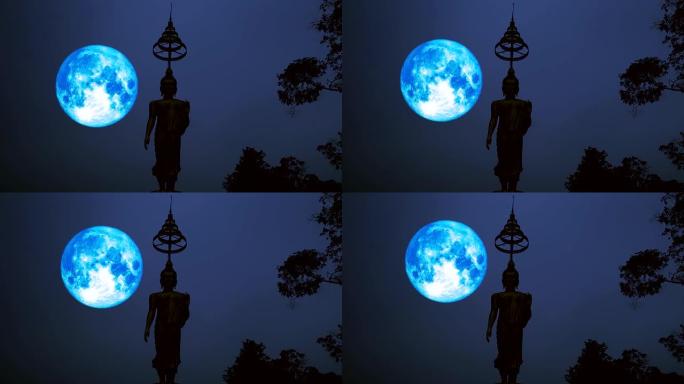 满蓝的收获月亮在夜空和剪影佛像上移动