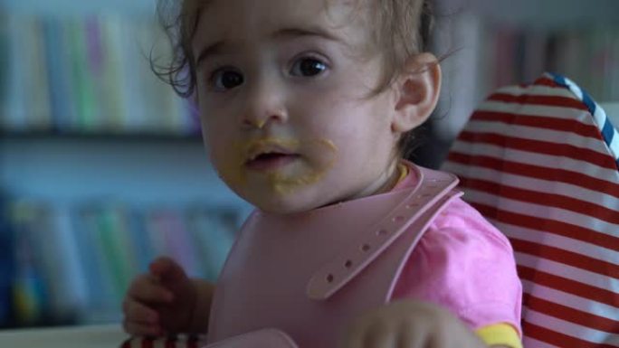 UHD视频女婴坐在喂奶椅上吃婴儿食品