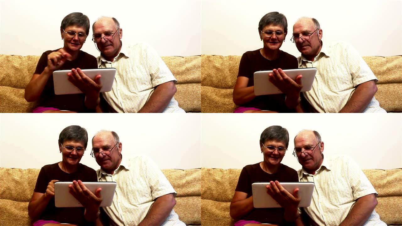 一对老年夫妇正坐在家里的沙发上，在平板电脑上看照片，面带微笑，积极交谈。