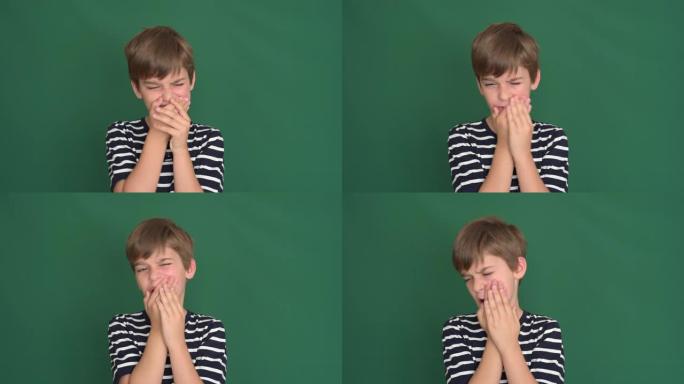 牙痛的小男孩在绿色屏幕上抱着脸颊