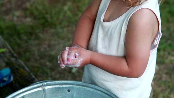一个孩子在后院洗手的手特写