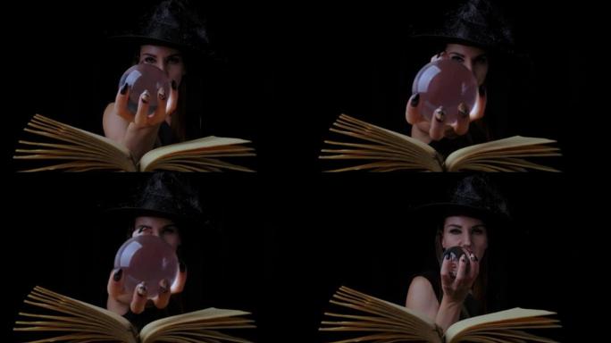穿着黑色女巫服装和帽子的美丽性感女人，手里拿着一个透明的魔术球，让人联想到。特写。万圣节节日派对