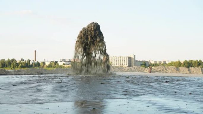 一个大喷泉与沙子混合，从金属管上拍打着蓝天。采砂。