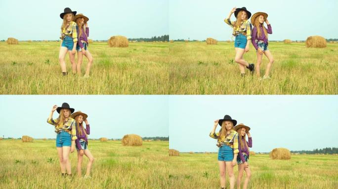 戴着牛仔帽的女孩站在乡下的田野上