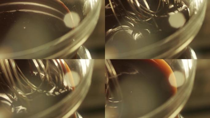 特写混合器在玻璃碗中搅打巧克力。贝克与搅拌机一起工作
