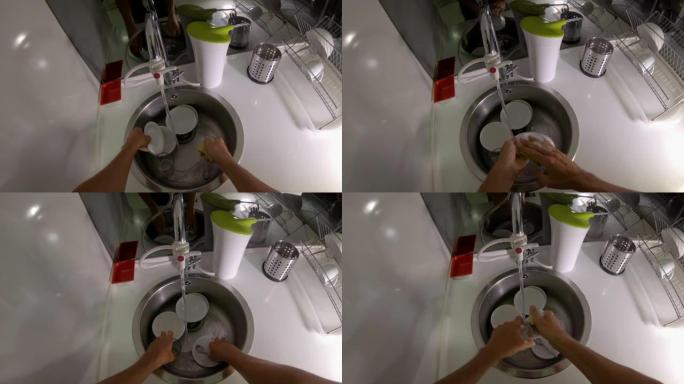 一名男子在厨房洗盘子和玻璃杯的慢镜头