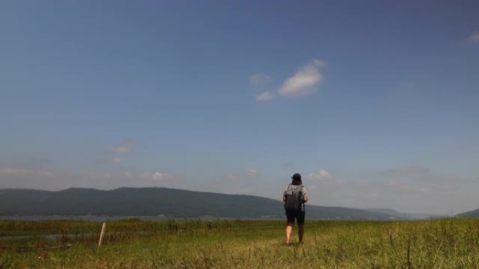 在晴朗的日子里，女性游客独自走在户外