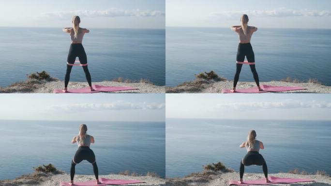运动的女人在海洋附近的户外用橡皮筋蹲下，慢动作