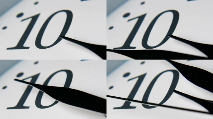 白色钟盘，三只长指针快速移动。小时箭头显示十。